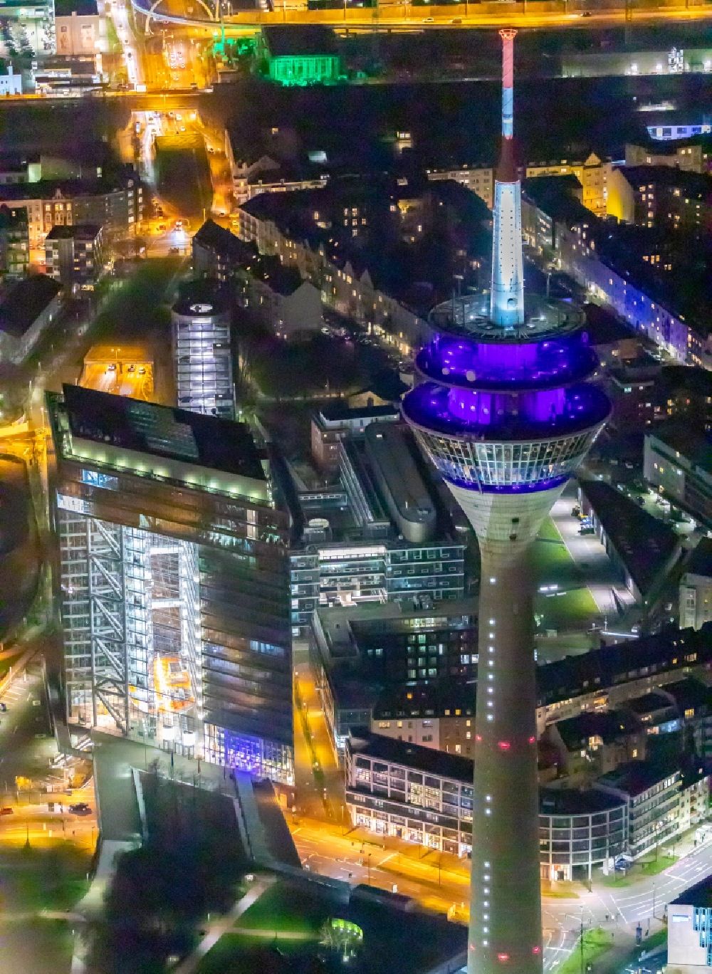 Aerial photograph at night Düsseldorf - Night lighting top of the Television Tower Rheinturm with the city center in the background in Duesseldorf in the state North Rhine-Westphalia