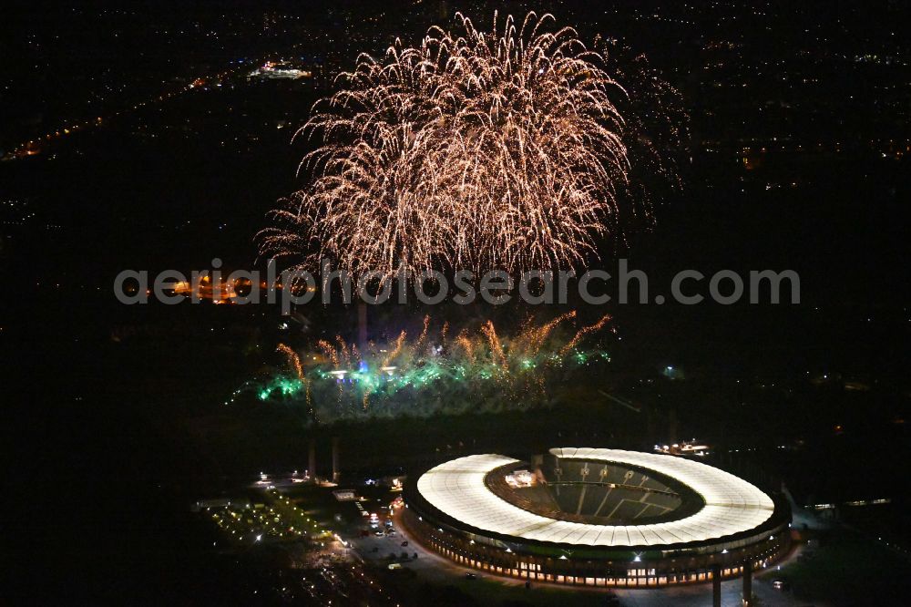 Berlin at night from the bird perspective: Night lighting Fireworks figures in the night sky above the event grounds of Pyronale Fireworks Competition at the Olympic Stadium in the district Charlottenburg in Berlin, Germany