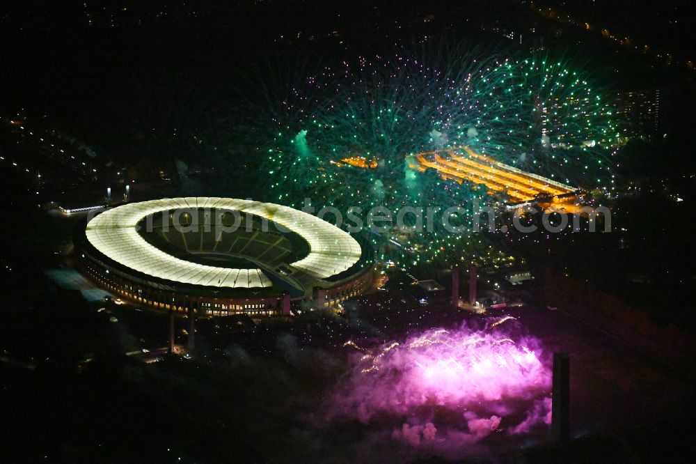 Aerial image at night Berlin - Night lighting Fireworks figures in the night sky above the event grounds of Pyronale Fireworks Competition at the Olympic Stadium in the district Charlottenburg in Berlin, Germany