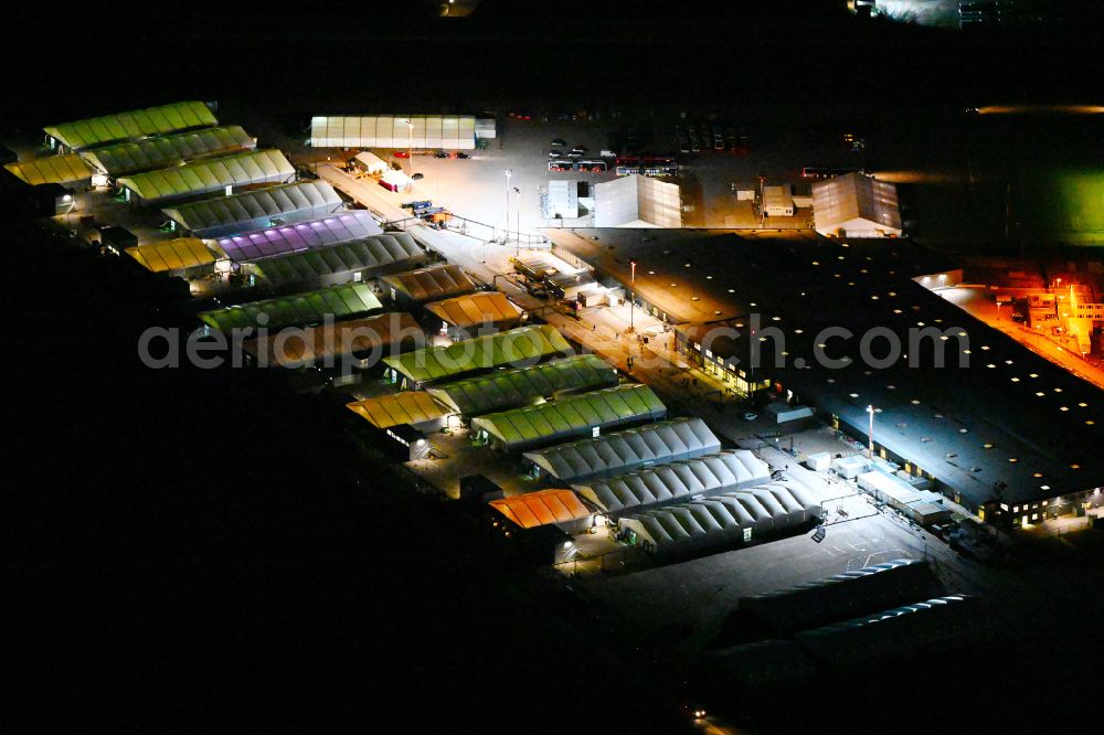 Berlin at night from the bird perspective: Night lights and lighting refugee home and asylum accommodation tent camp as makeshift accommodation Ukraine Arrivals Center TXL in the district of Tegel in Berlin, Germany