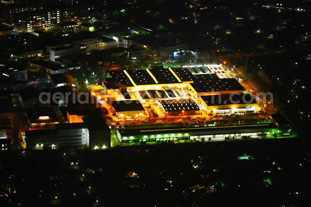 Aerial photograph at night Berlin - Night lighting Building of the construction market Holz Possling on Friedrich-Olbricht-Damm in the district Charlottenburg-Nord in Berlin, Germany
