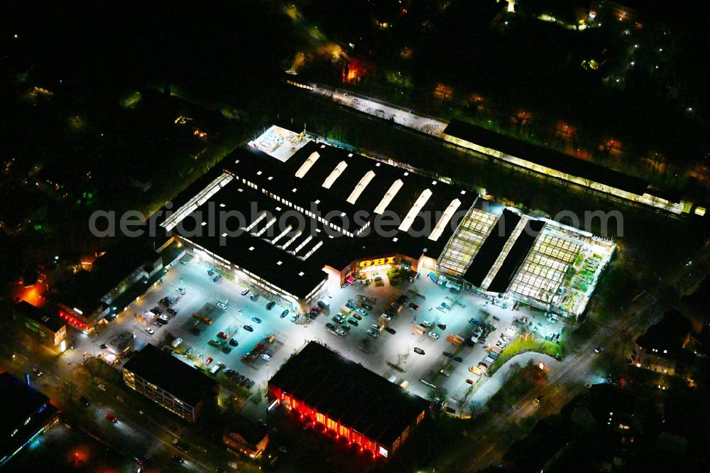 Aerial photograph at night Berlin - Night lighting building of the construction market OBI in the district Reinickendorf in Berlin, Germany