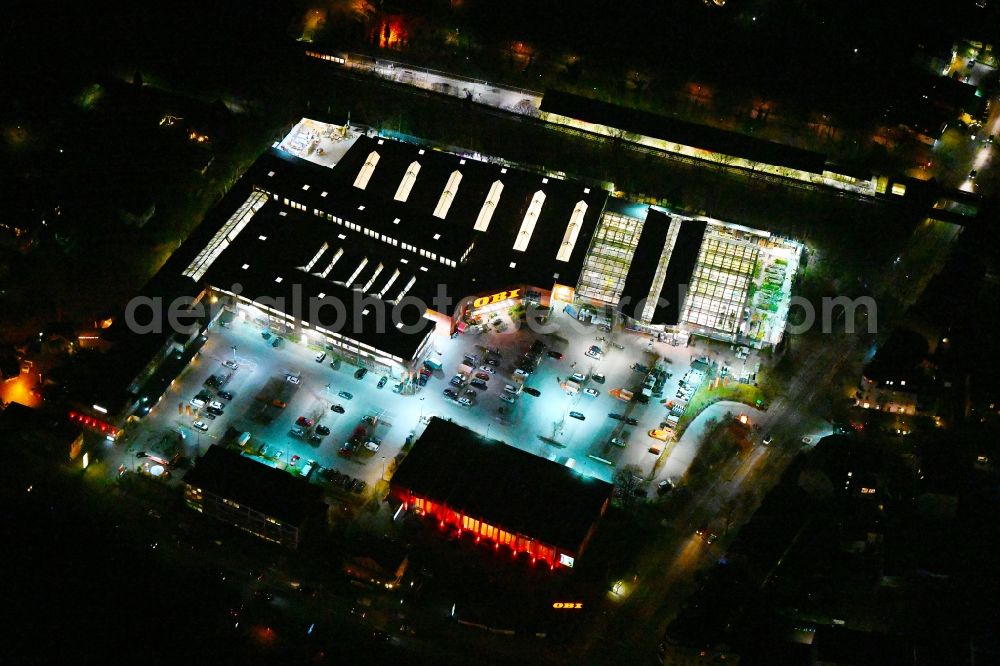 Aerial image at night Berlin - Night lighting building of the construction market OBI in the district Reinickendorf in Berlin, Germany