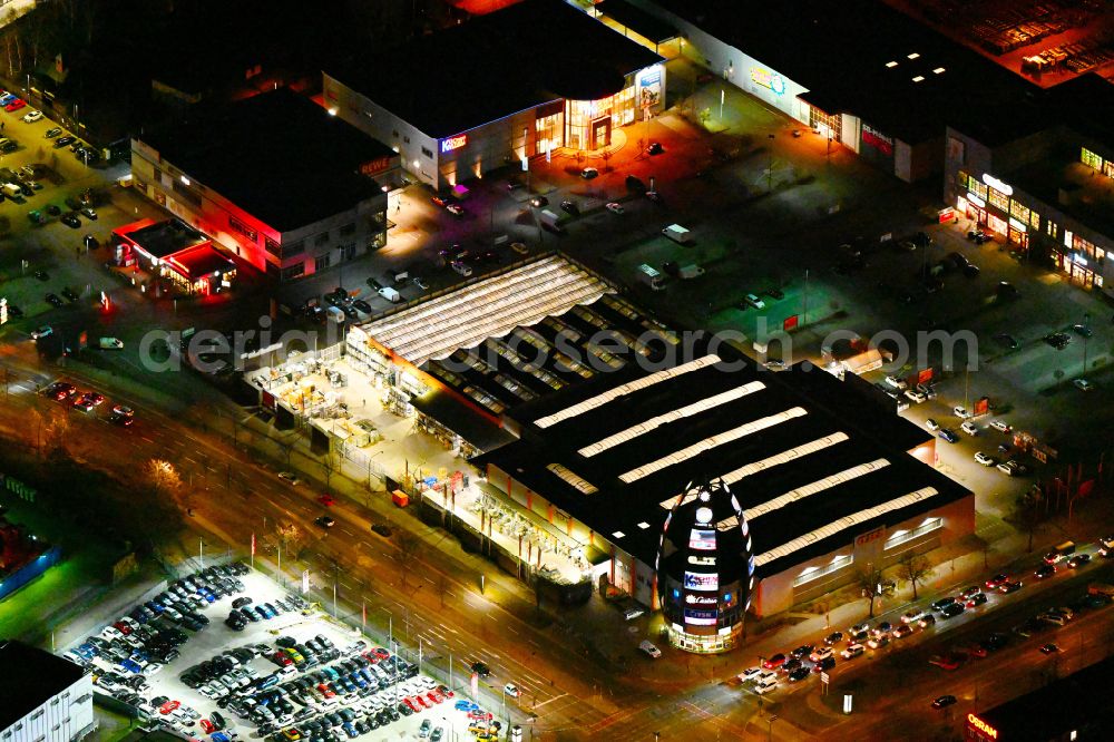 Aerial photograph at night Berlin - Night lighting building of the construction market OBI on street Nonnendammallee in the district Siemensstadt in Berlin, Germany