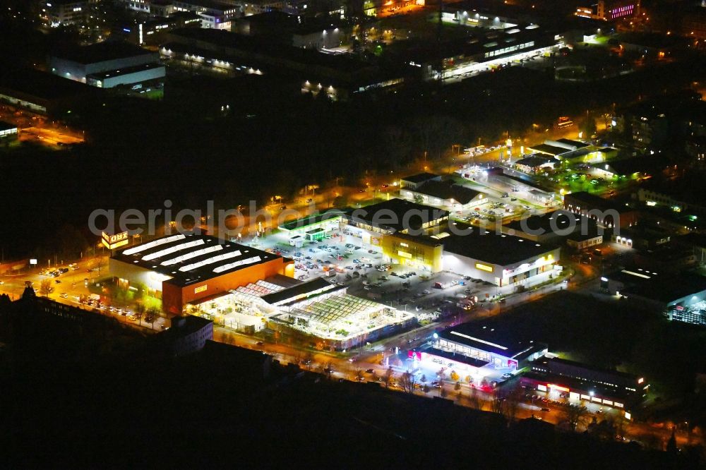 Berlin at night from the bird perspective: Night lighting Building of the construction market OBI Markt Berlin-Treptow on Adlergestell in the district Adlershof in Berlin, Germany