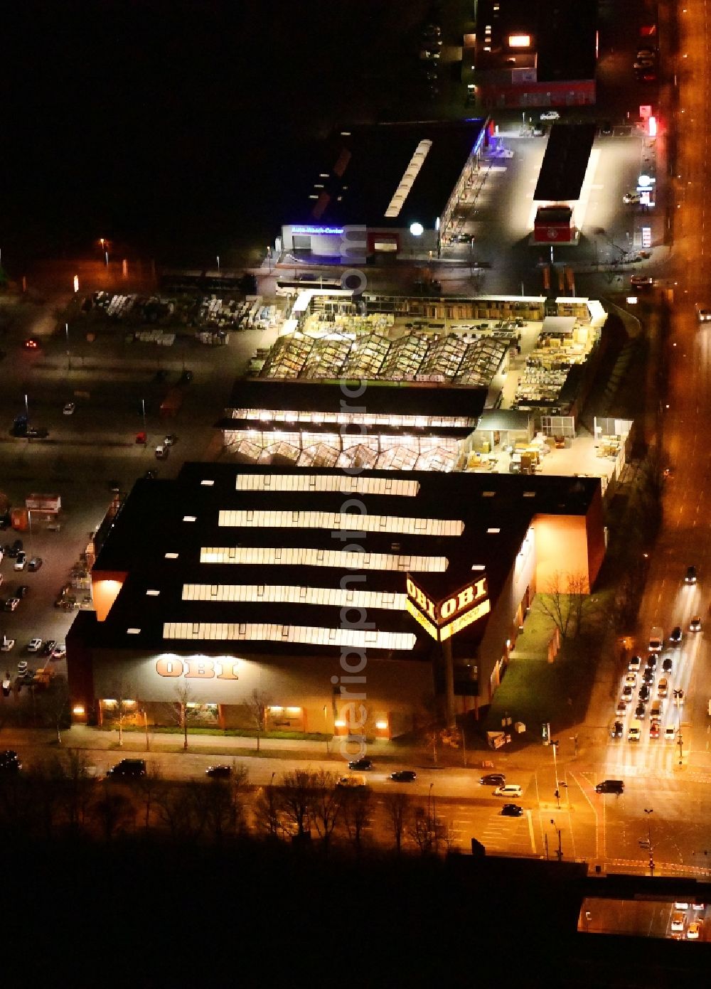 Berlin at night from the bird perspective: Night lighting Building of the construction market OBI Markt Berlin-Treptow on Adlergestell in the district Adlershof in Berlin, Germany