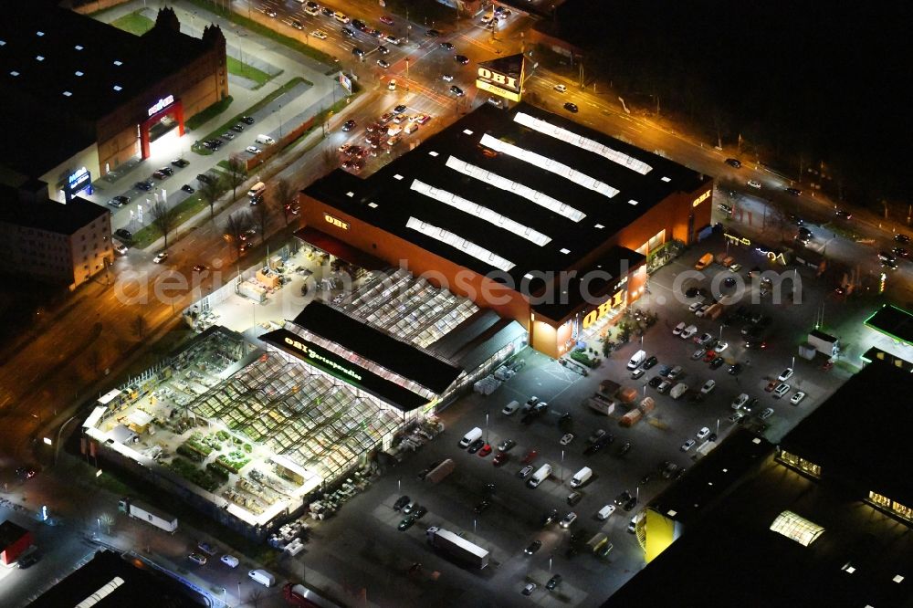 Aerial photograph at night Berlin - Night lighting Building of the construction market OBI Markt Berlin-Treptow on Adlergestell in the district Adlershof in Berlin, Germany