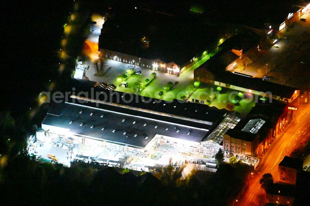 Aerial image at night Lutherstadt Wittenberg - Night lighting Building of the construction market of OBI in Lutherstadt Wittenberg in the state Saxony-Anhalt