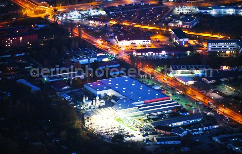 Strausberg at night from the bird perspective: Night lighting Building of the construction market OBI Markt in Strausberg in the state Brandenburg, Germany