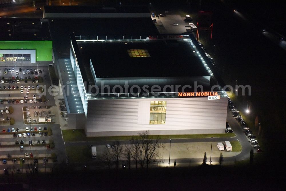 Eschborn at night from the bird perspective: Night view Building of the store - furniture market XXXL Mann Mobilia in Sulzbach (Taunus) in the state Hesse