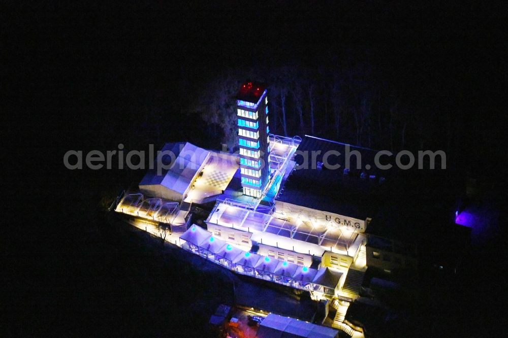 Aerial photograph at night Berlin - Night lighting Site of the tower- building ensemble of Mueggelturm in the forest Mueggelbergen Koepenick in Berlin