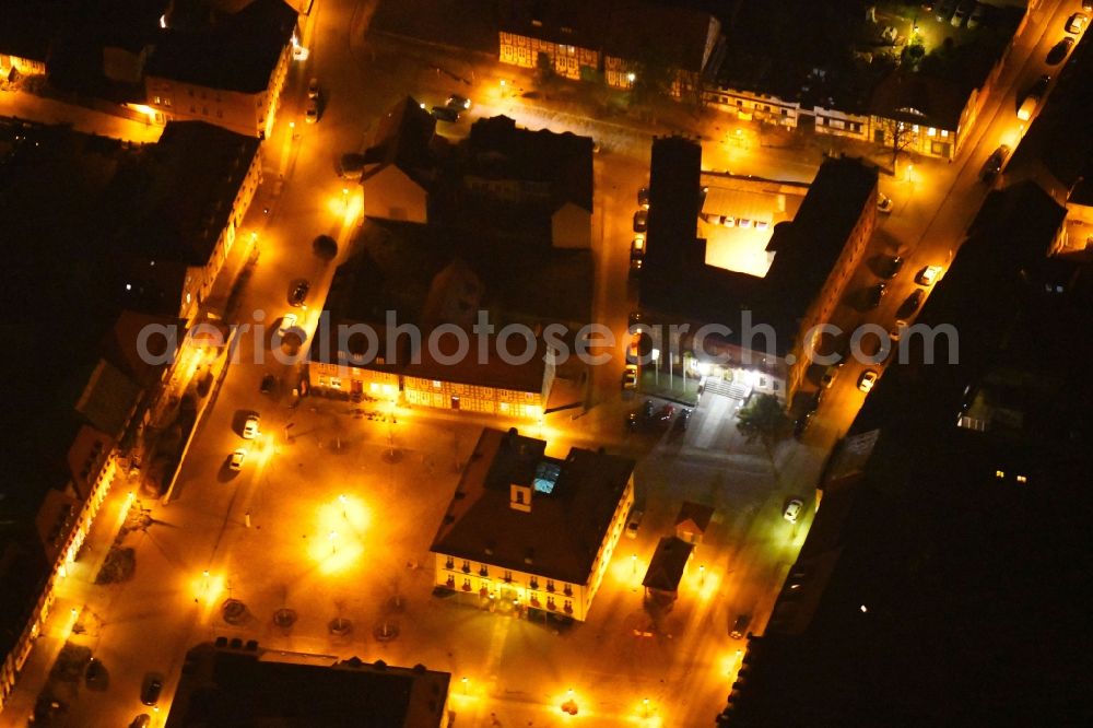 Angermünde at night from the bird perspective: Night lighting Town Hall building of the City Council at the market downtown in Angermuende in the state Brandenburg, Germany