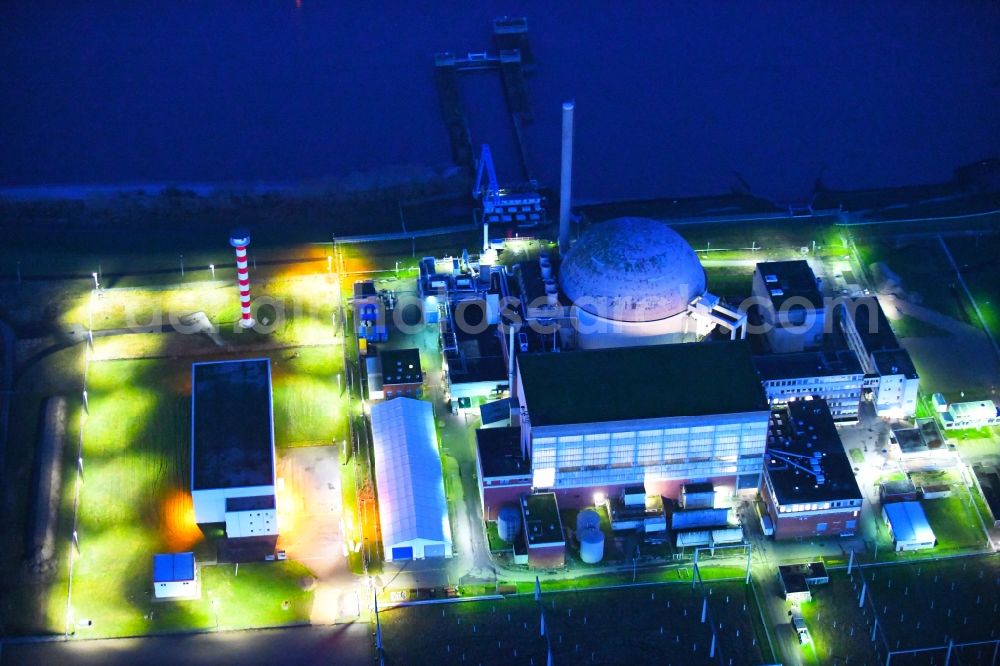 Aerial image at night Stade - Night lighting building the decommissioned reactor units and systems of the NPP - NPP nuclear power plant in Stadersand in the state Lower Saxony