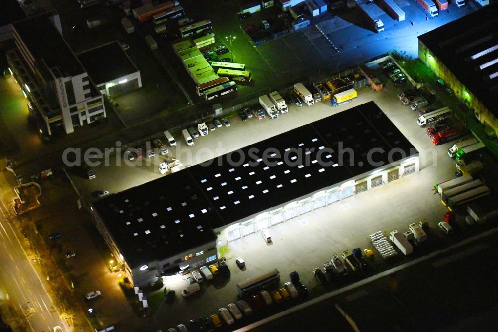 Aerial photograph at night Berlin - Night lighting building complex and grounds of the truck automotive repair shop MAN Truck & Bus Service on Siegfriedstrasse in the district Lichtenberg in Berlin, Germany