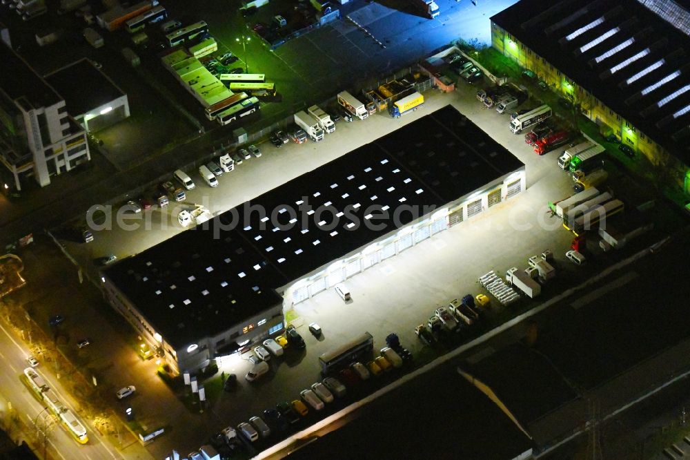 Aerial image at night Berlin - Night lighting building complex and grounds of the truck automotive repair shop MAN Truck & Bus Service on Siegfriedstrasse in the district Lichtenberg in Berlin, Germany
