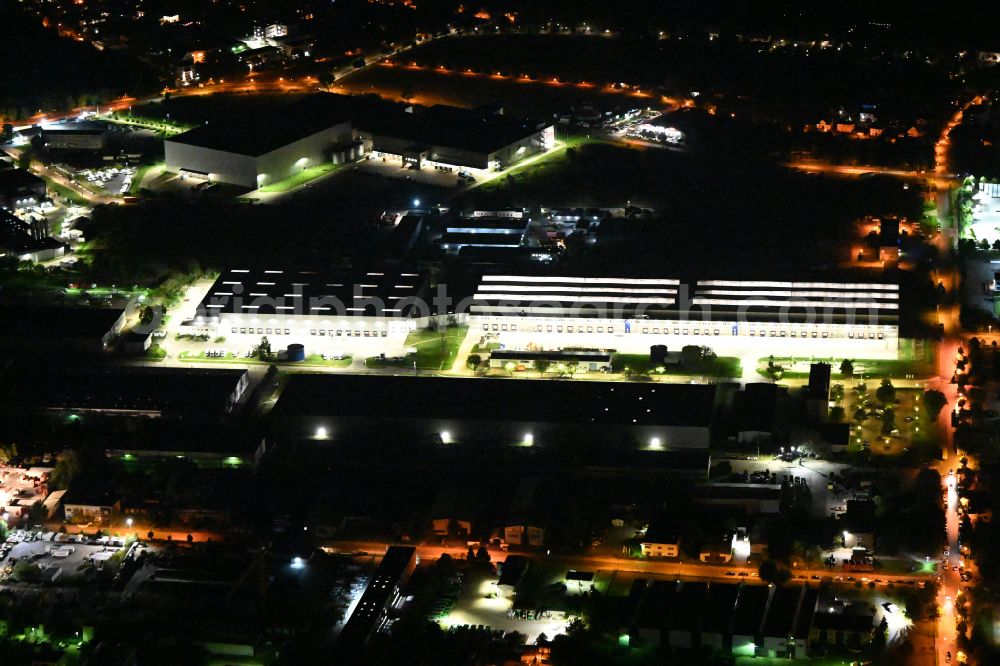 Aerial photograph at night Hoppegarten - Night lighting Building complex and grounds of the logistics center of Rhenus Home Delivery GmbH in of Industriestrasse in Hoppegarten in the state Brandenburg, Germany