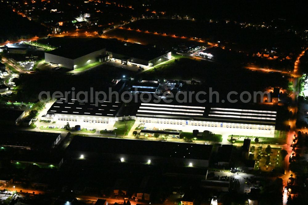Aerial image at night Hoppegarten - Night lighting Building complex and grounds of the logistics center of Rhenus Home Delivery GmbH in of Industriestrasse in Hoppegarten in the state Brandenburg, Germany
