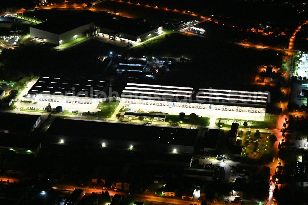 Hoppegarten at night from above - Night lighting Building complex and grounds of the logistics center of Rhenus Home Delivery GmbH in of Industriestrasse in Hoppegarten in the state Brandenburg, Germany
