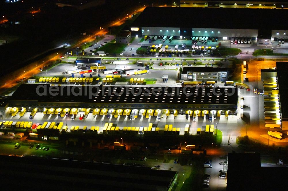 Schönefeld at night from the bird perspective: Night lighting building complex and distribution center on the site of DACHSER SE An den Gehren in Schoenefeld in the state Brandenburg, Germany