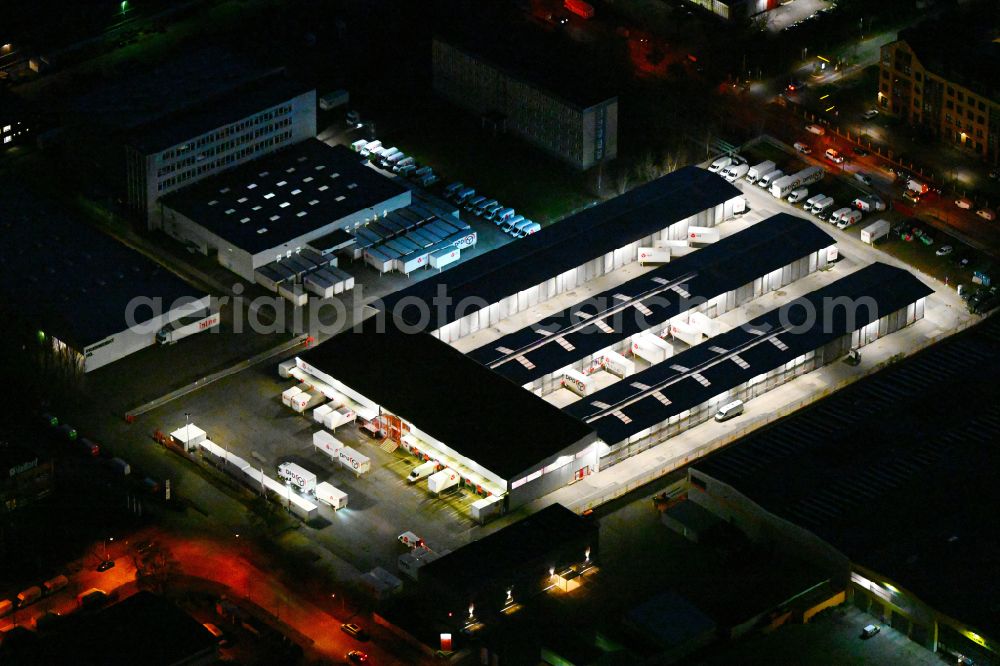 Berlin at night from the bird perspective: Night lighting building complex and distribution center on the site of DPD Deuter Paketdienst in the district Hohenschoenhausen in Berlin, Germany