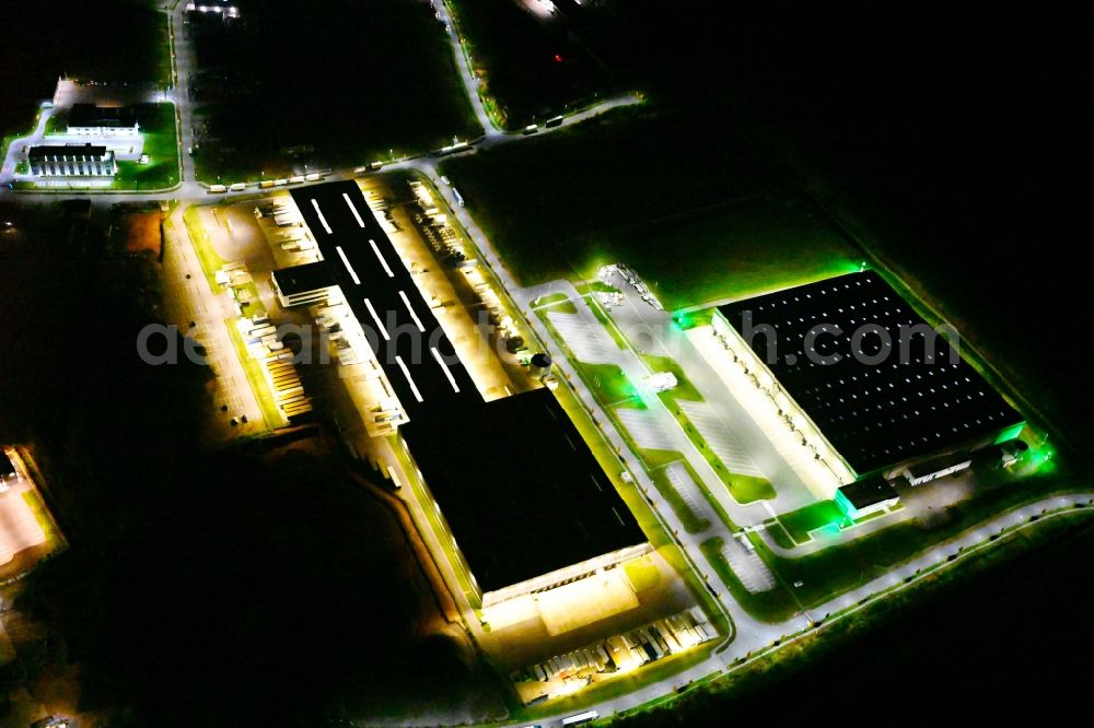 Kirkel at night from the bird perspective: Night lighting building complex and distribution center on the site of DSV Road GmbH in Kirkel in the state Saarland, Germany