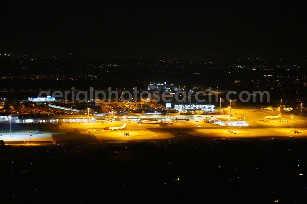 Schönefeld at night from the bird perspective: Night lighting Runway with hangar taxiways and terminals on the grounds of the airport Berlin-Schoenefeld in Schoenefeld in the state Brandenburg, Germany