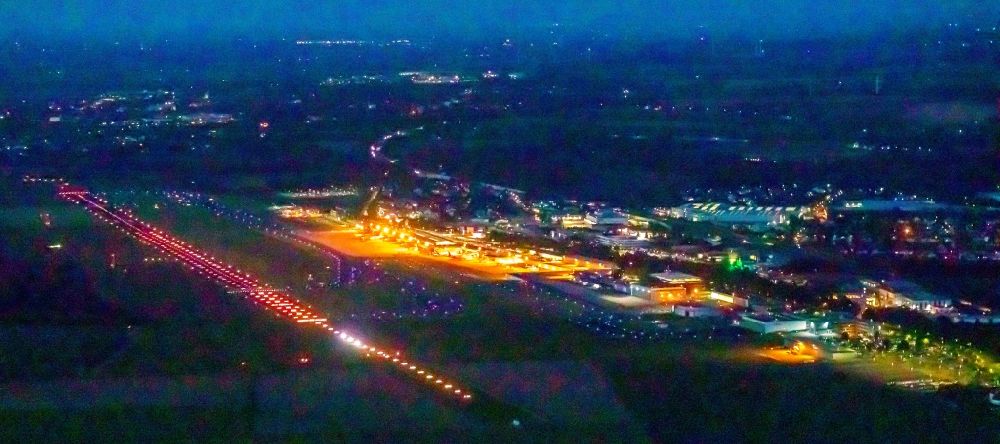 Aerial photograph at night Dortmund - Night lighting runway with hangar taxiways and terminals on the grounds of the airport in Dortmund at Ruhrgebiet in the state North Rhine-Westphalia, Germany