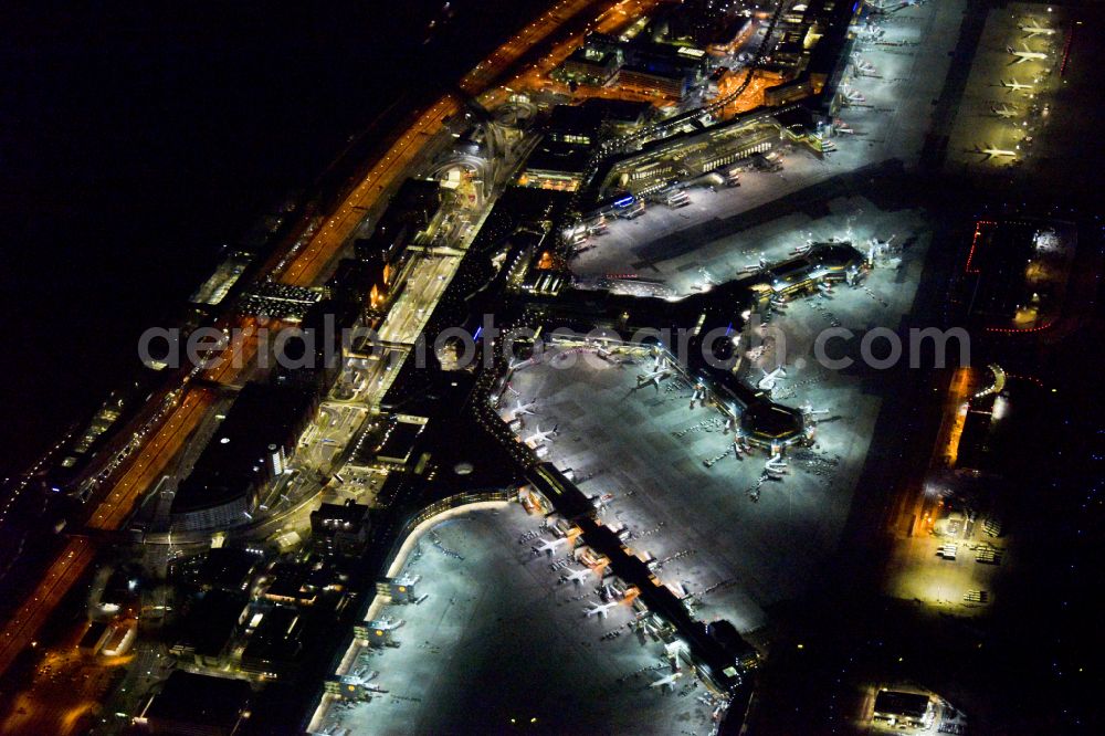 Frankfurt am Main at night from the bird perspective: Night lighting runway with hangar taxiways and terminals on the grounds of the airport in Frankfurt in the state Hesse, Germany