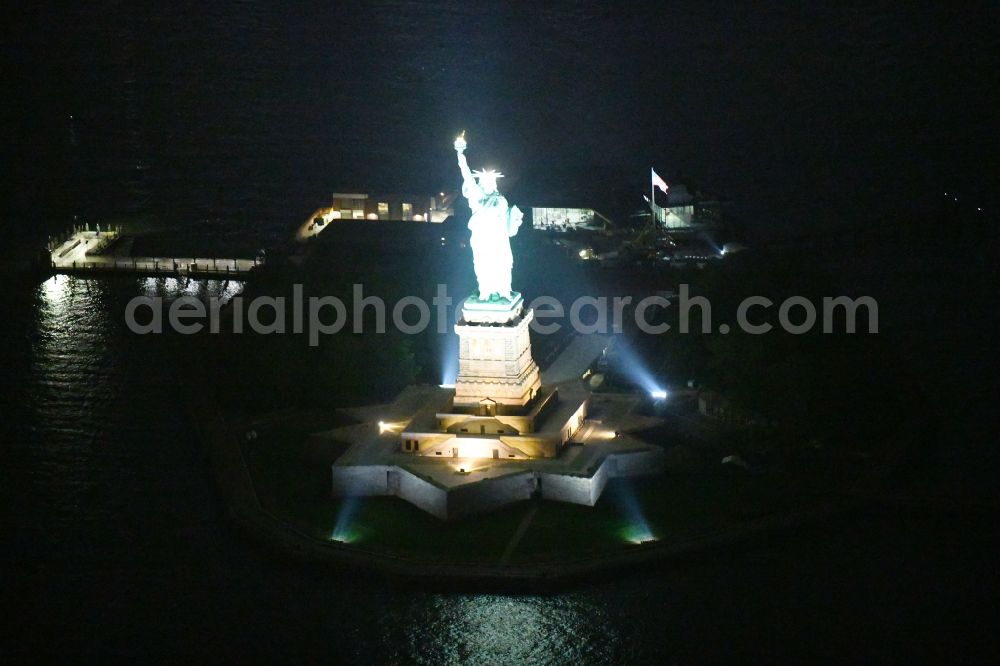 New York at night from the bird perspective: Night lighting Tourist attraction of the historic monument Freiheitsstatue - Statue of Liberty National Monument in the district Manhattan in New York in United States of America