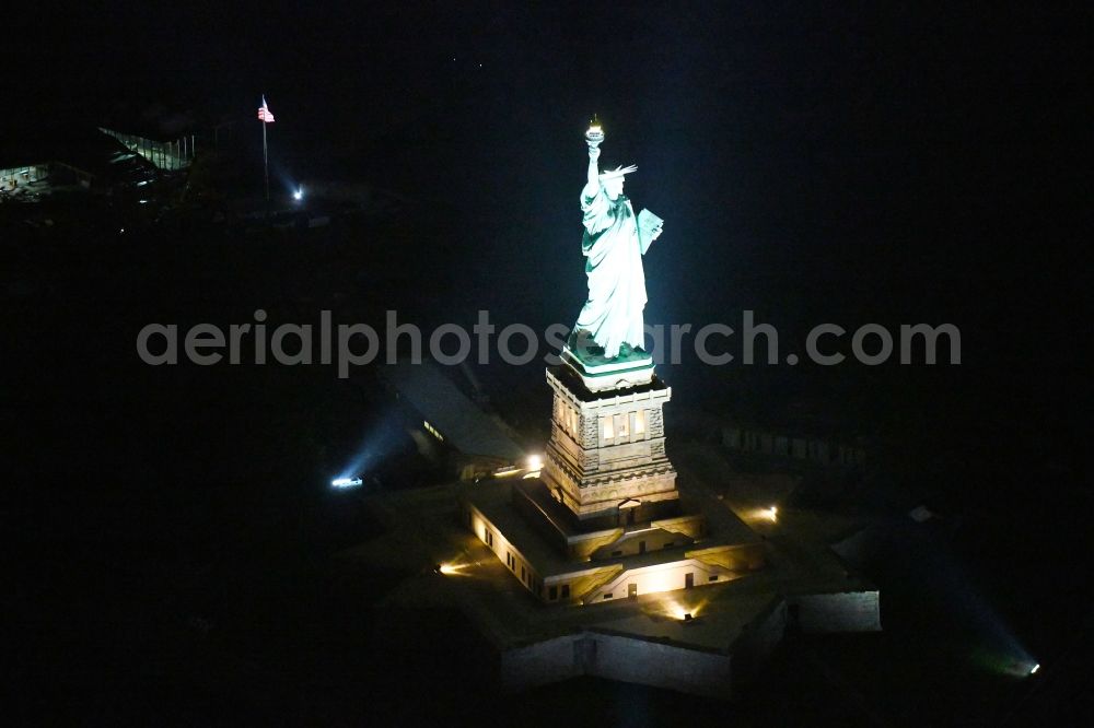 New York at night from above - Night lighting Tourist attraction of the historic monument Freiheitsstatue - Statue of Liberty National Monument in the district Manhattan in New York in United States of America