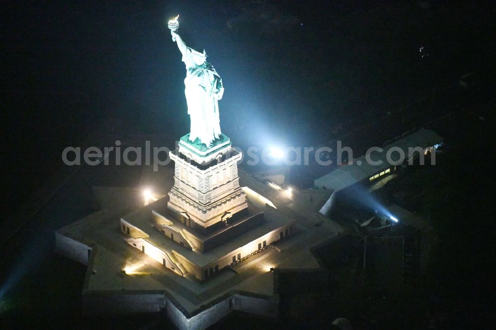 New York at night from the bird perspective: Night lighting Tourist attraction of the historic monument Freiheitsstatue - Statue of Liberty National Monument in the district Manhattan in New York in United States of America