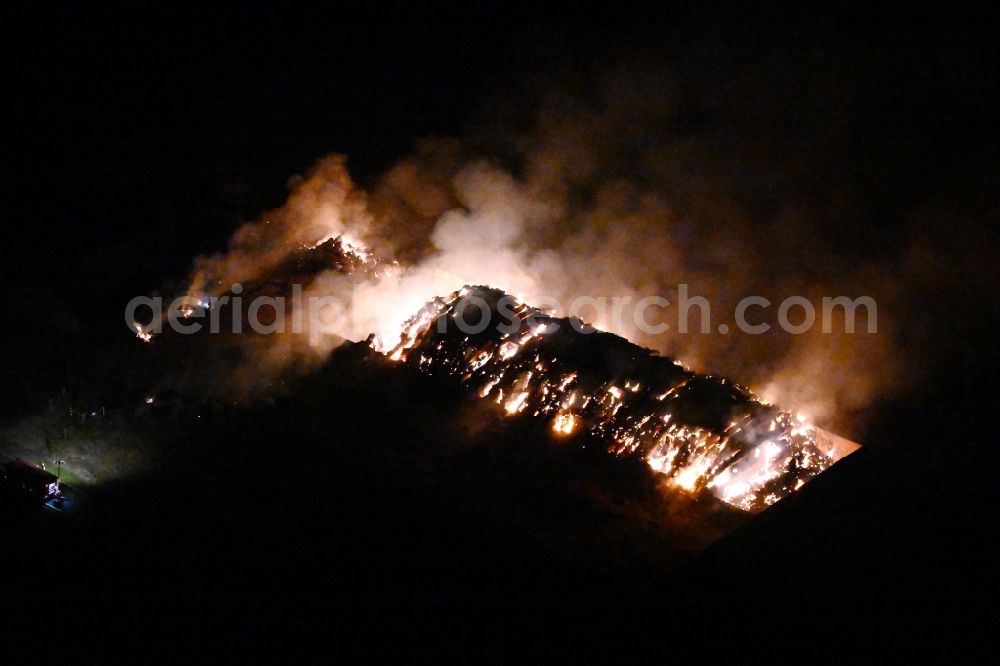 Bad Lauchstädt at night from above - Night lighting fire controlled by the fire brigade - major fire in a straw bale silage bale stack on an agricultural storage area on the country road L173 in Bad Lauchstaedt in the state Saxony-Anhalt, Germany