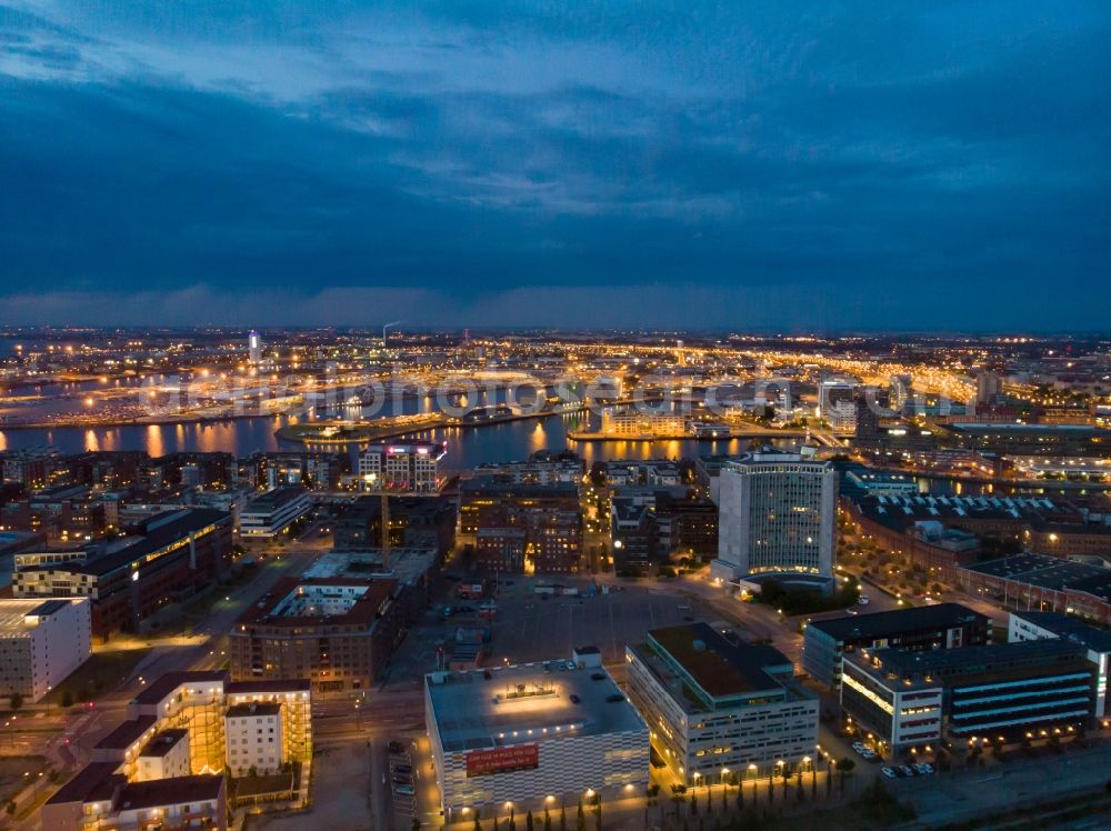 Malmö at night from the bird perspective: Night lighting port facilities on the seashore of the Baltic Sea in the district Hamnen in Malmoe in Skane laen, Sweden