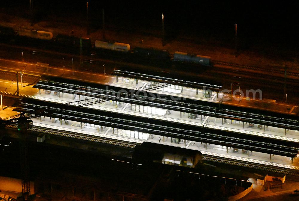 Bitterfeld at night from the bird perspective: Night lighting track progress and building of the main station of the railway on street Bahnhofstrasse in Bitterfeld in the state Saxony-Anhalt, Germany