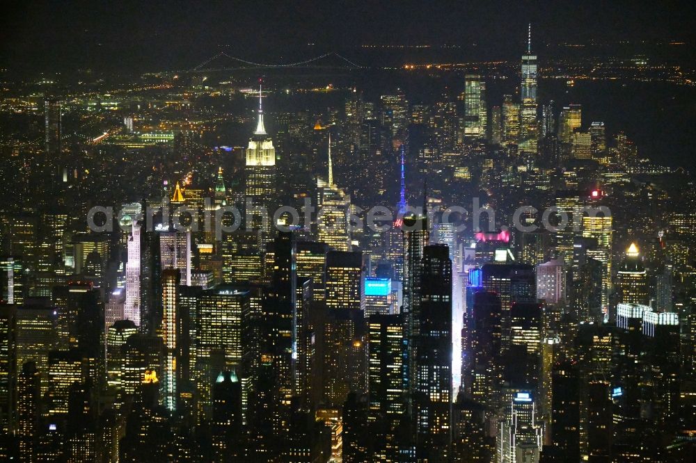 Aerial image at night New York - Night lighting High-rise ensemble in the district Manhattan in New York in United States of America