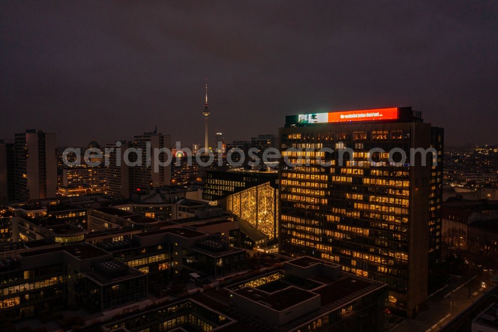 Aerial image at night Berlin - Night lighting office and corporate management high-rise building of Axel-Springer Verlages on street Rudi- Dutschke- Strasse - Axel- Springer- Strasse in the district Kreuzberg in Berlin, Germany