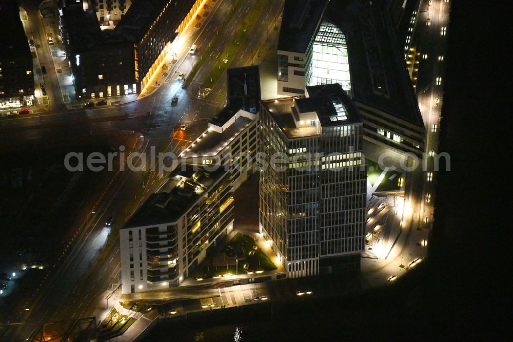 Hamburg at night from the bird perspective: Night lighting build a new office and commercial building Intelligent Quarters in of Hafen City in Hamburg, Germany