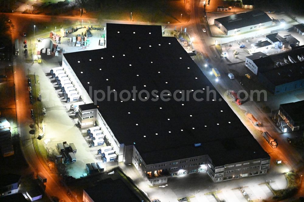 Siek at night from the bird perspective: Night lighting high-bay warehouse building complex and logistics center on the premises of Walter WESEMEYER GmbH on Jacobsrade in Siek in the state Schleswig-Holstein, Germany