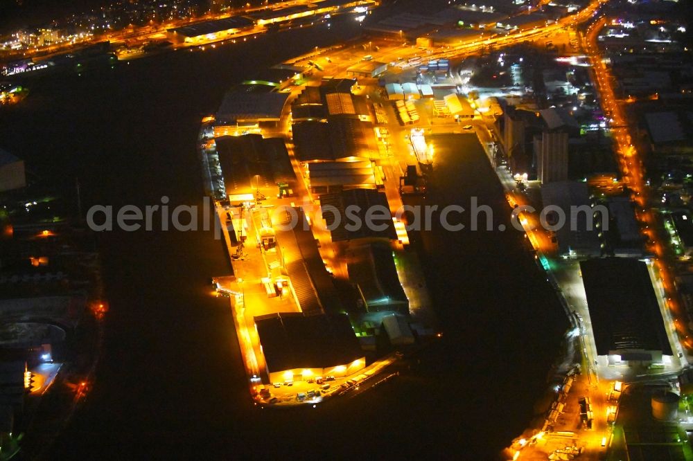 Aerial photograph at night Lübeck - Night lighting quays and boat moorings at the port of the inland port on shore of Trave in the district Falkenfeld - Vorwerk in Luebeck in the state Schleswig-Holstein, Germany