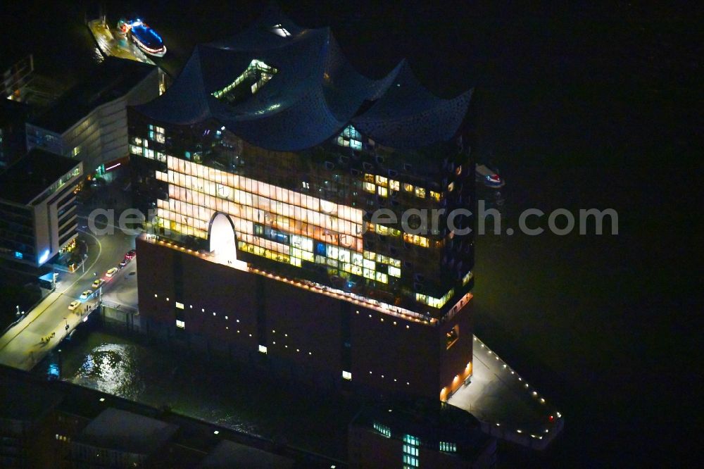 Hamburg at night from the bird perspective: Night lighting The Elbe Philharmonic Hall on the river bank of the Elbe in Hamburg