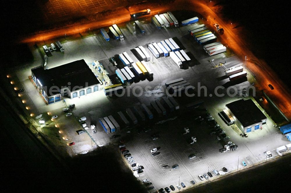 Lübeck at night from the bird perspective: Night lighting warehouses and forwarding building of Heisterkamp Transportation Solutions on Henry-Koch-Strasse in the district Ivendorf in Luebeck in the state Schleswig-Holstein, Germany