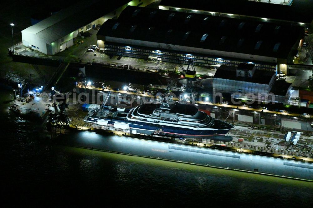 Hamburg at night from above - Night lighting ship's hull of Luxury - yachts for maintenance, conversion and modernization in dry dock on the shipyard site in the district Steinwerder in Hamburg, Germany