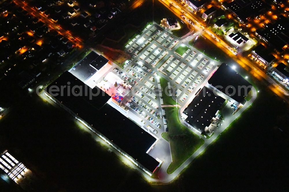 Berlin at night from the bird perspective: Night lighting site for the new building home-center of the Porta-Group at Pilgramer street in the district Mahlsdorf in Berlin