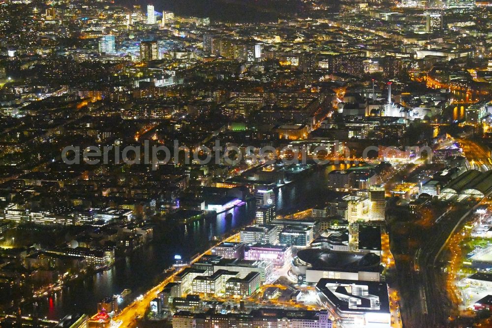 Aerial image at night Berlin - Night lighting Arena Mercedes-Benz-Arena on Friedrichshain part of Berlin. The former O2 World - now Mercedes-Benz-Arena - is located in the Anschutz Areal, a business and office space on the riverbank