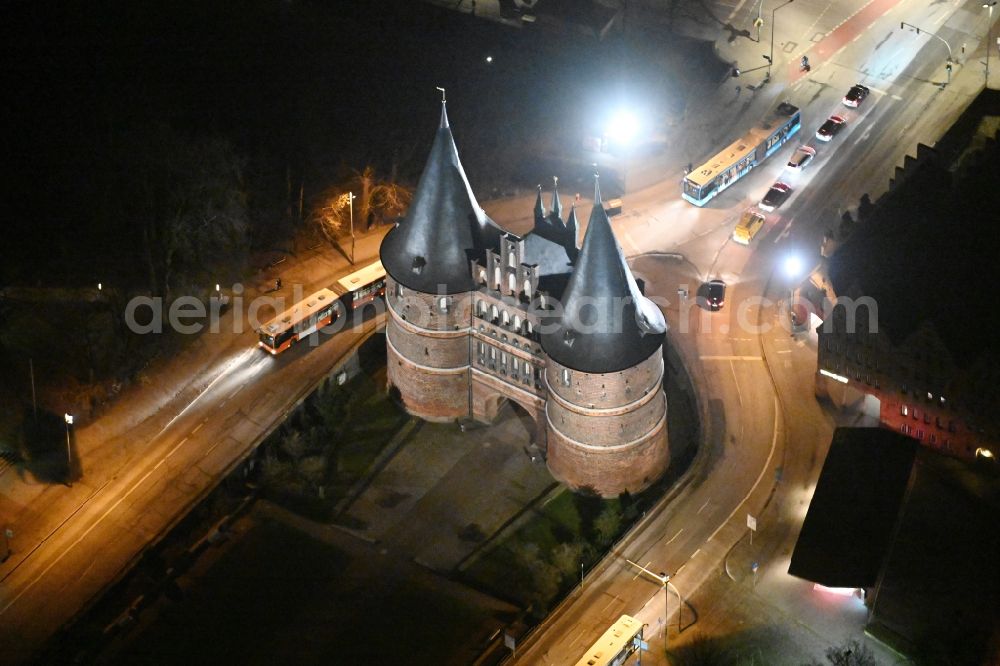 Lübeck at night from the bird perspective: Night lighting museum building complex Museum Holsten on Holstentor place in Luebeck in Schleswig-Holstein