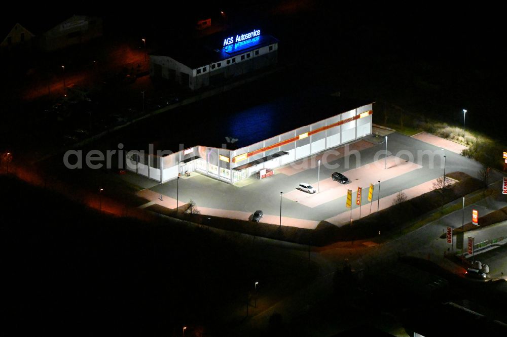 Bürgel at night from the bird perspective: Night lighting building complex of local supply center on street In den Satteln in Buergel in the state Thuringia, Germany