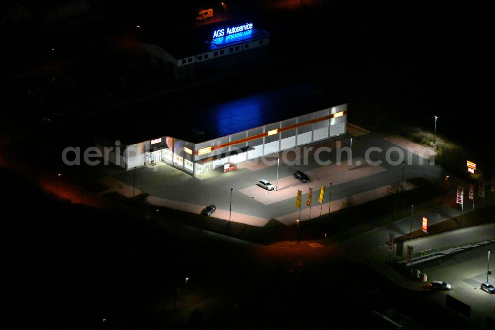 Aerial image at night Bürgel - Night lighting building complex of local supply center on street In den Satteln in Buergel in the state Thuringia, Germany