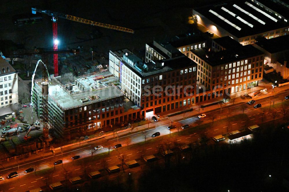 München at night from the bird perspective: Night lighting construction site to build a new office and commercial building on street Moosacher Strasse in the district Milbertshofen in Munich in the state Bavaria, Germany
