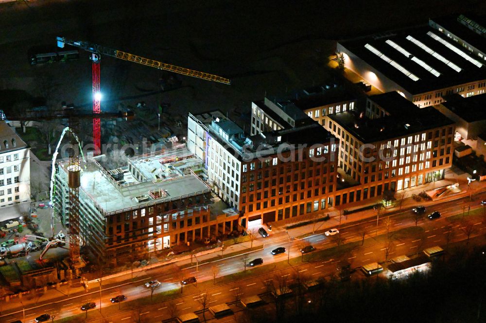 München at night from the bird perspective: Night lighting construction site to build a new office and commercial building on street Moosacher Strasse in the district Milbertshofen in Munich in the state Bavaria, Germany
