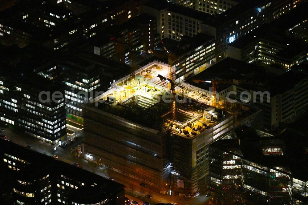 Hamburg at night from the bird perspective: Night lighting construction site to build a new office and commercial building of Olympus Campus on Heidenkonpsweg - Wendenstrasse in Hamburg, Germany
